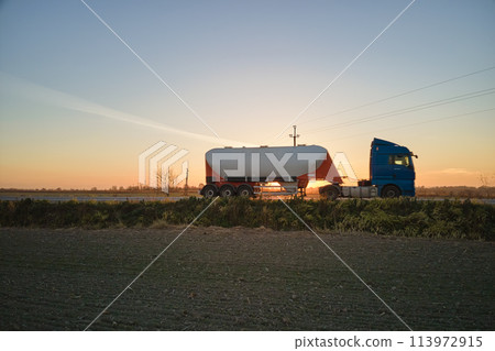 Aerial view of blurred fast moving cement cargo truck driving on highway hauling goods. Delivery transportation and logistics concept 113972915