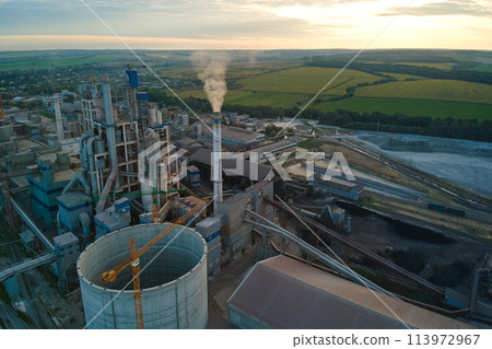 Aerial view of cement factory with high concrete plant structure and tower crane at industrial production area. Manufacture and global industry concept. Aerial view of cement factory with high concrete plant structure and tower crane at industrial production area. Manufacture and global industry concept. 113972967