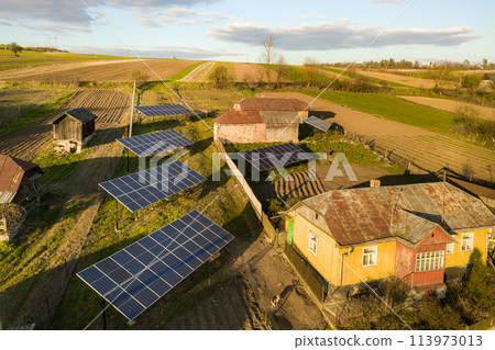 Aerial top down view of solar panels in green rural village yard. 113973013