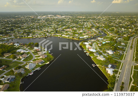 Aerial view of rural private houses in remote suburbs located on sea coast near Florida wildlife wetlands with green vegetation on gulf bay shore. Living close to nature in tropical region concept 113973037
