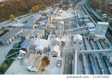 Aerial view of cargo train loaded with crushed stone materials at mining factory. Railway transportation of grinded limestone ore 113973040