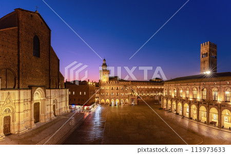 Sunset light bathes Piazza Maggiore in Bologna, highlighting the grandeur of its medieval structures 113973633