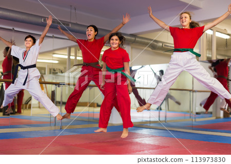 Children jumping with instructor at gym 113973830