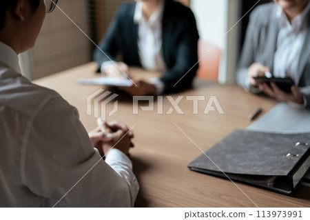 HR manager woman reading resume and asking questions with male candidate while job interviewing 113973991