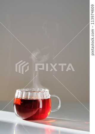 Glass mug with hot black tea on the table. 113974609