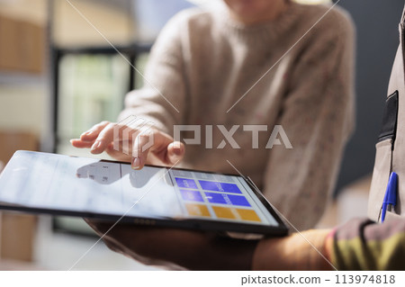 Diverse team analyzing goods quality control report on tablet computer, working at customers orders in storehouse. Stockroom employee preparing packages for delivery, checking clients detalis Diverse team analyzing goods quality control report on tablet computer, working at customers orders in storehouse. Stockroom employee preparing packages for delivery, checking clients detalis 113974818