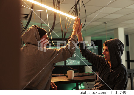 Successful cyberattack, happy hackers giving high five, hacking server, stealing business data. Scammers cracking computer system password, breaking into banking account at night time Successful cyberattack, happy hackers giving high five, hacking server, stealing business data. Scammers cracking computer system password, breaking into banking account at night time 113974961