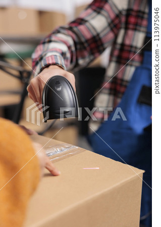 Warehouse employee scanning cardboard box barcode while doing inventory control. Delivery service operator managing parcel receiving and checking qr code with scanner close up Warehouse employee scanning cardboard box barcode while doing inventory control. Delivery service operator managing parcel receiving and checking qr code with scanner close up 113975046