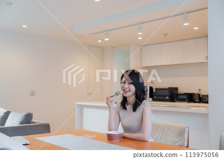 A young woman eating a convenience store bento at home 113975056