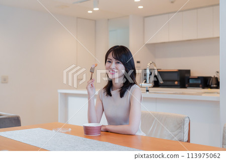 A young woman eating a convenience store bento at home 113975062