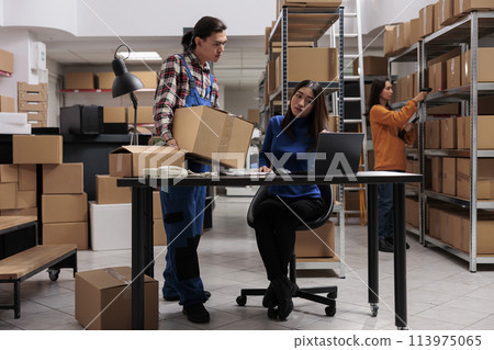 Warehouse asian operators team managing package delivery in storage room. Storehouse worker holding parcel ready for transportation and woman coworker scheduling shipment Warehouse asian operators team managing package delivery in storage room. Storehouse worker holding parcel ready for transportation and woman coworker scheduling shipment 113975065