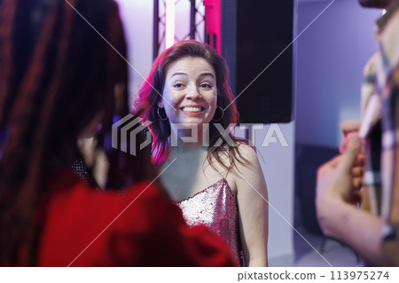 Smiling cheerful woman partying with friends and socializing at nightclub discotheque. Carefree happy girl clubbing and attending disco social gathering event, enjoying nightlife leisure 113975274