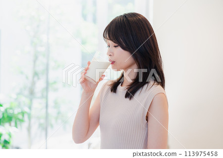 在家喝牛奶的年輕女人 113975458