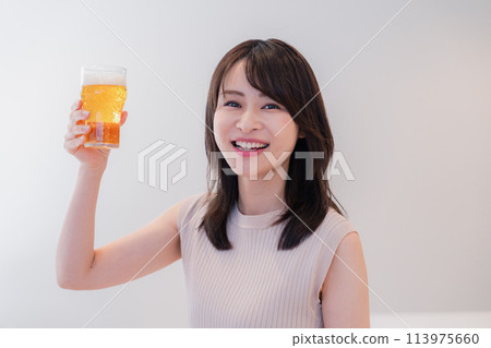 Smiling young woman drinking beer 113975660
