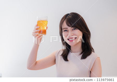 年輕女子微笑著喝啤酒 113975661