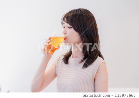 Smiling young woman drinking beer 113975665