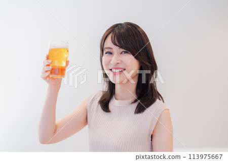 年輕女子微笑著喝啤酒 年輕女子微笑著喝啤酒 113975667