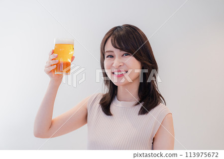 Smiling young woman drinking beer Smiling young woman drinking beer 113975672