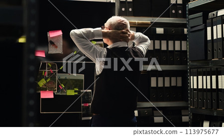 Criminologist review evidence on board, trying to find new case details and clues to solve mystery. Senior criminal expert conducting investigation, looking at forensic reports. 113975677
