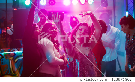 Happy girl taking pictures on phone, recording video for memories to have fun at disco party event. Woman partying with group of friends and taking photos, filming on smartphone. Handheld shot. Happy girl taking pictures on phone, recording video for memories to have fun at disco party event. Woman partying with group of friends and taking photos, filming on smartphone. Handheld shot. 113975803