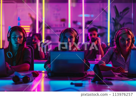 Varied team of young professionals collaborates on a project in a lively, neon-lit office space Varied team of young professionals collaborates on a project in a lively, neon-lit office space 113976257