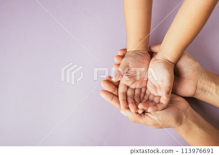 Top view of parents and kid holding empty hands together on a color background. Family day celebrating togetherness and support. 113976691