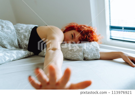 morning, young woman waking up in bed with natural hair under arms 113976921