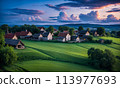 Panoramic top view of an old small abandoned ruined village on the hills with thatched roof huts at sunset with clouds in the sky 113977693