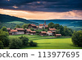 Panoramic top view of an old small abandoned ruined village on the hills with thatched roof huts at sunset with clouds in the sky 113977695