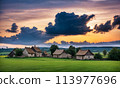 Panoramic top view of an old small abandoned ruined village on the hills with thatched roof huts at sunset with clouds in the sky 113977696