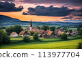 Panoramic top view of an old small abandoned ruined village on the hills with thatched roof huts at sunset with clouds in the sky 113977704