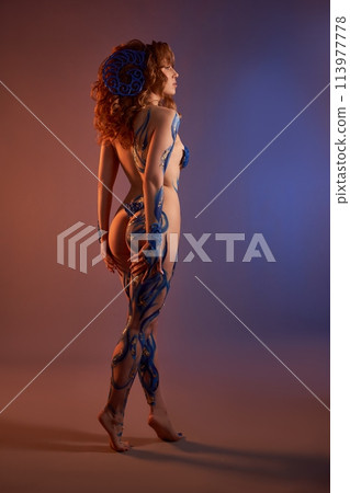 Fairy naked woman in body art with horns on her head in studio 113977778