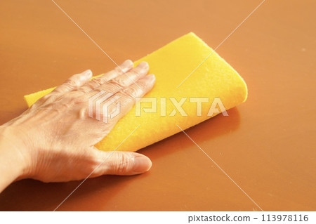A woman wiping a table with a sponge wipe (sponge cloth) 113978116
