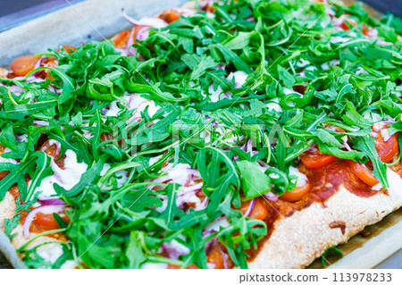 Enjoy a pizza party with homemade pizza with arugula, fresh tomatoes, and red onions Enjoy a pizza party with homemade pizza with arugula, fresh tomatoes, and red onions 113978233