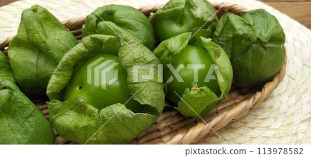 Six fresh shelled tomatillos in a basket (Mexico) 113978582