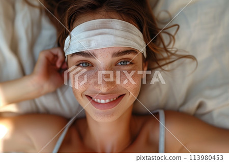 Woman with headband lying on the bed 113980453