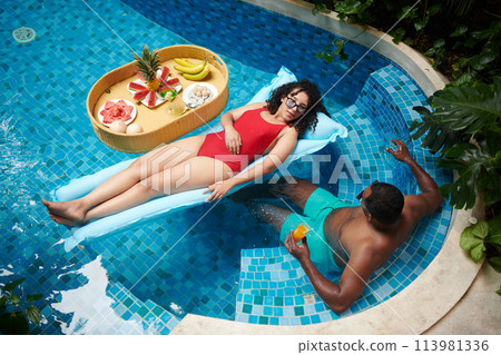Young restful couple in swimming pool 113981336
