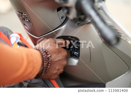 Bike owner pushing button on panel Bike owner pushing button on panel 113981400