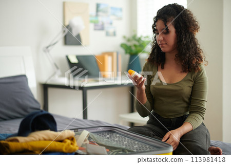 Female traveler choosing sunblock lotion 113981418