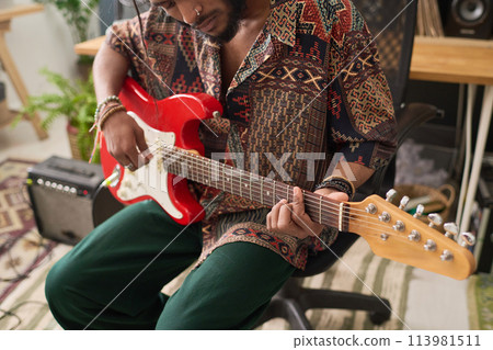 Bass guitar in hands of male musician 113981511