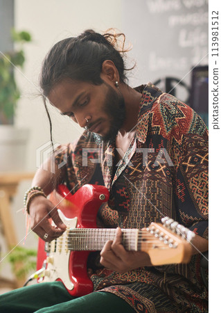 Guy with bass guitar creating new music 113981512