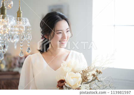 穿著婚紗的年輕女子的個人資料，例如前期照片拍攝和新娘派對的照片。 113981597