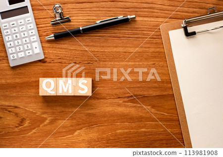 有一個木製立方體，上面寫著 QMS。引人注目的圖像 113981908