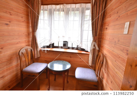 A bright dining corner with the warmth of wood and a relaxing dining space with a small window 113982250