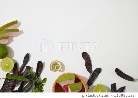 Fresh organic compositions flat lay on white table, lemon, grapefruit and black locust pod. Copy space for text with high angle shot Fresh organic compositions flat lay on white table, lemon, grapefruit and black locust pod. Copy space for text with high angle shot 113983152