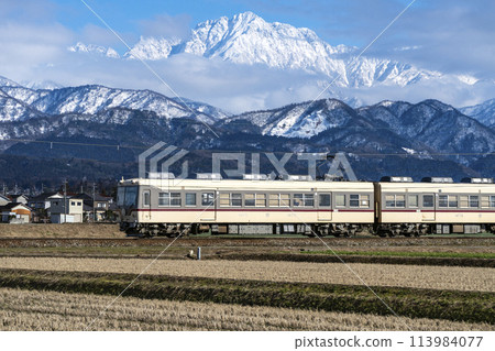A Toyama Chiho Railway train running with a view of Mount Tsurugi A Toyama Chiho Railway train running with a view of Mount Tsurugi 113984077
