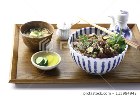 Marinated raw bonito rice bowl served on a tray (Rice bowl with bonito sashimi marinated in a ginger-flavored sauce and generously placed on top of rice Marinated raw bonito rice bowl served on a tray (Rice bowl with bonito sashimi marinated in a ginger-flavored sauce and generously placed on top of rice 113984942