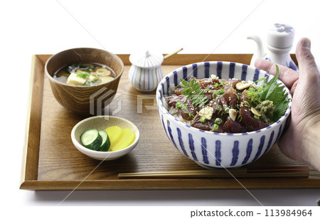 Marinated raw bonito rice bowl served on a tray (Rice bowl with bonito sashimi marinated in a ginger-flavored sauce and generously placed on top of rice Marinated raw bonito rice bowl served on a tray (Rice bowl with bonito sashimi marinated in a ginger-flavored sauce and generously placed on top of rice 113984964