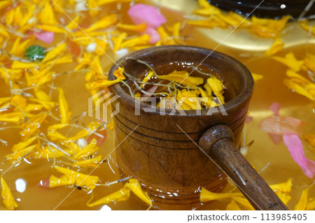 bamboo ladles and flower petals with water    113985405