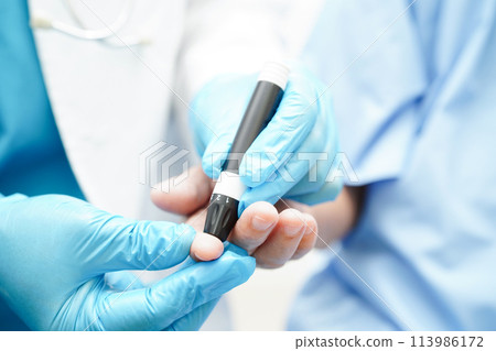 Asian doctor using lancet pen on senior patient finger for check sample blood sugar level to treatment diabetes. Asian doctor using lancet pen on senior patient finger for check sample blood sugar level to treatment diabetes. 113986172